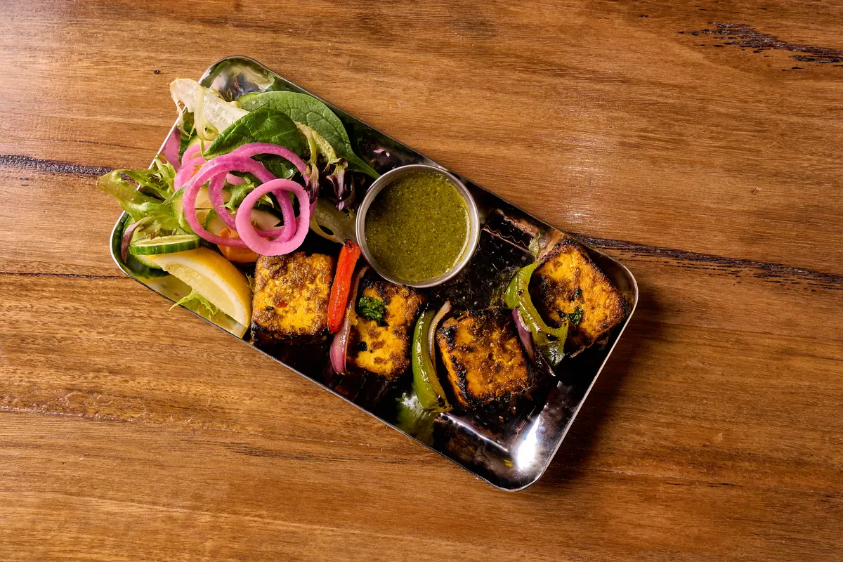 Charred paneer cubes with capsicum, sliced onion, lemon and green chutney.
